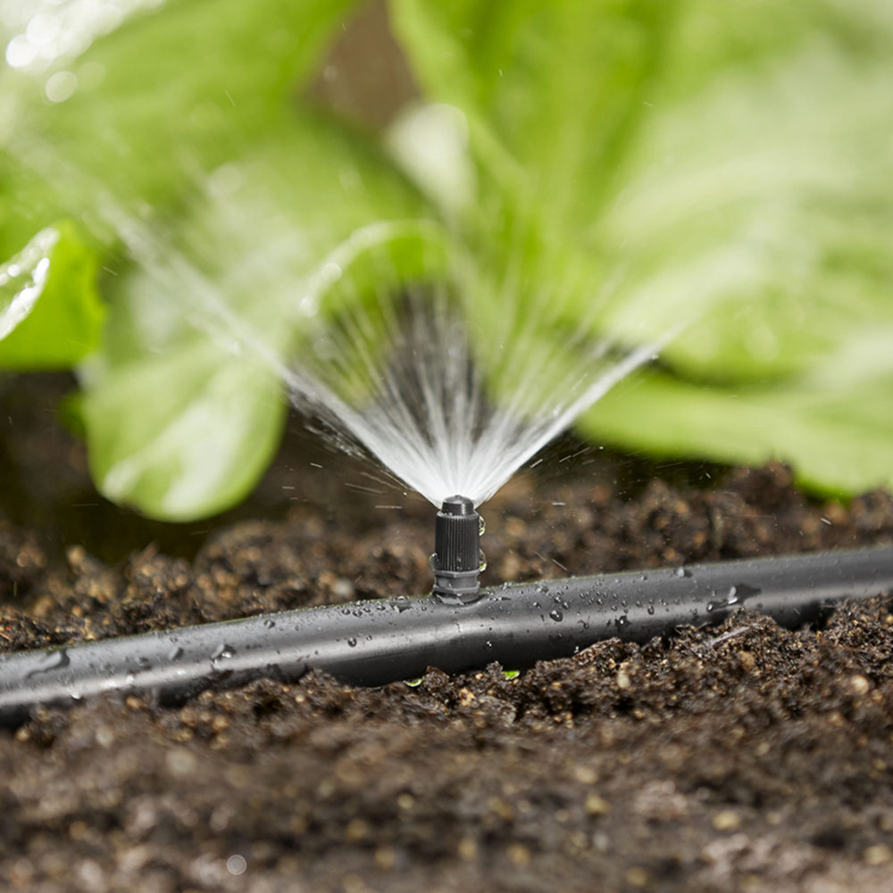 Expert technician from Utah Sprinkler Pros adjusting water-saving irrigation system in Utah County garden