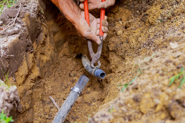Irrigation specialist testing valve box and controller for hidden sprinkler faults, Irrigation technician testing pressure and adjusting sprinkler heads for balanced lawn coverage